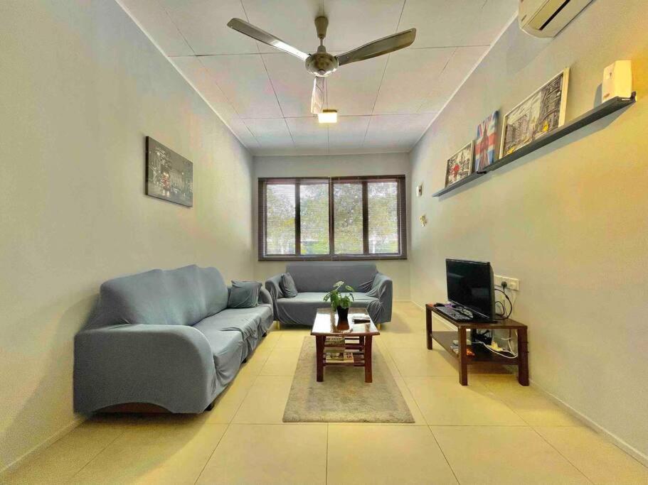 a living room with a couch and a tv at Relax Home 4-8 Pax Sunway Lagoon & Sunway Pyramid in Kampong Penaga