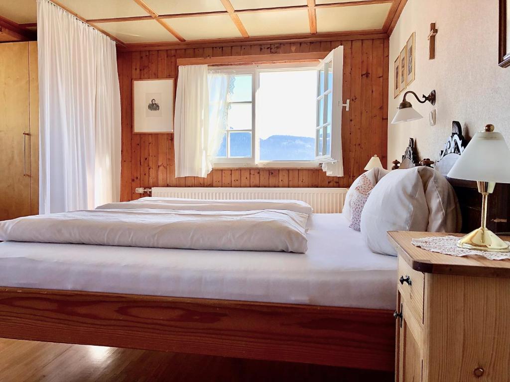 a bedroom with a large bed with a window at Bio Ferienbauernhof Greber in Schwarzenberg