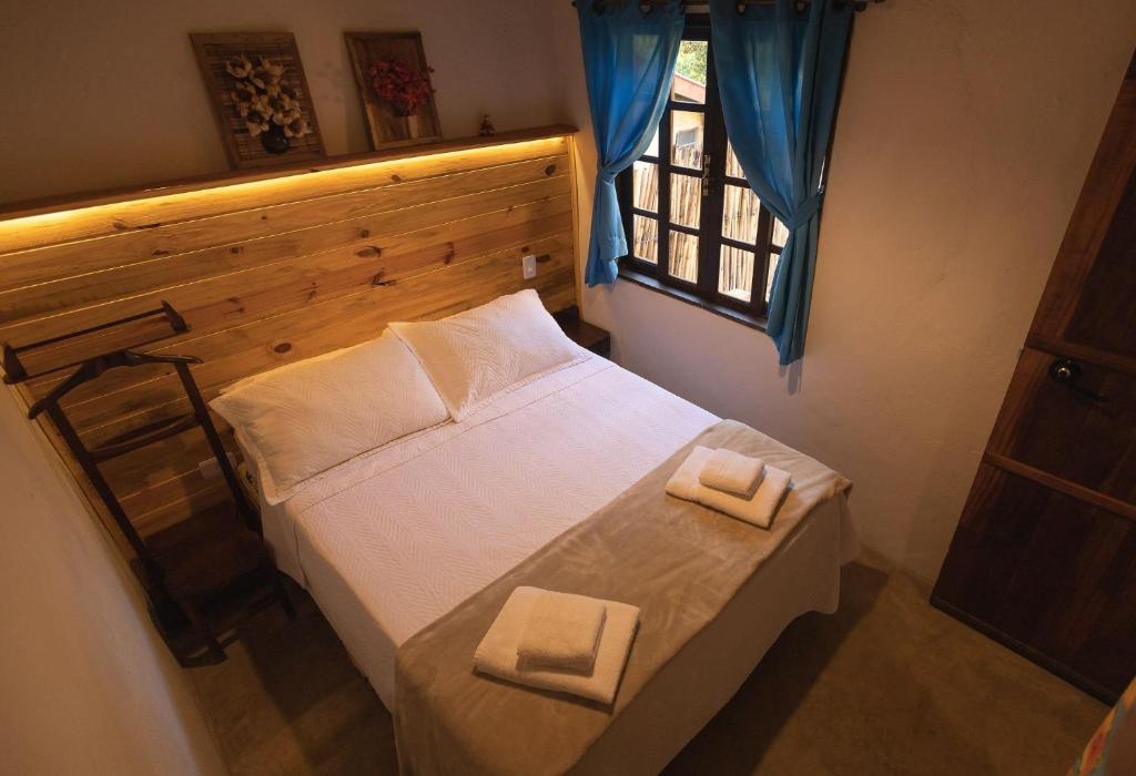 a bedroom with a bed with two towels on it at Casa aconchegante no coração do Bairro do Quilombo in São Bento do Sapucaí