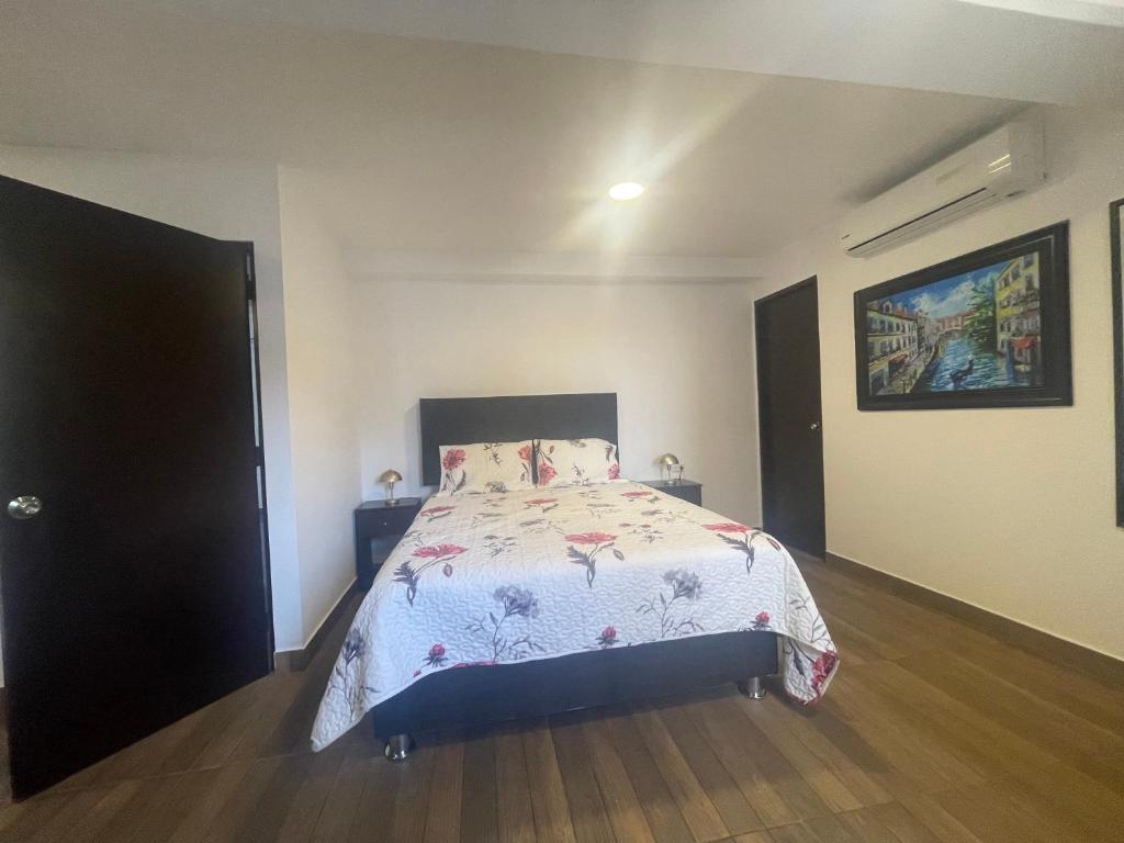 een slaapkamer met een bed met een bloemenbed bij 15 Acogedor dpto de un ambiente en miraflores in Lima