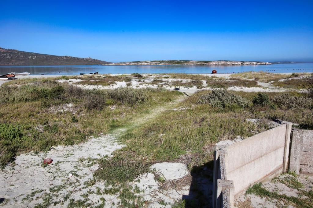 a path in the sand next to a body of water at Oppi Stuppi Langebaan in Langebaan