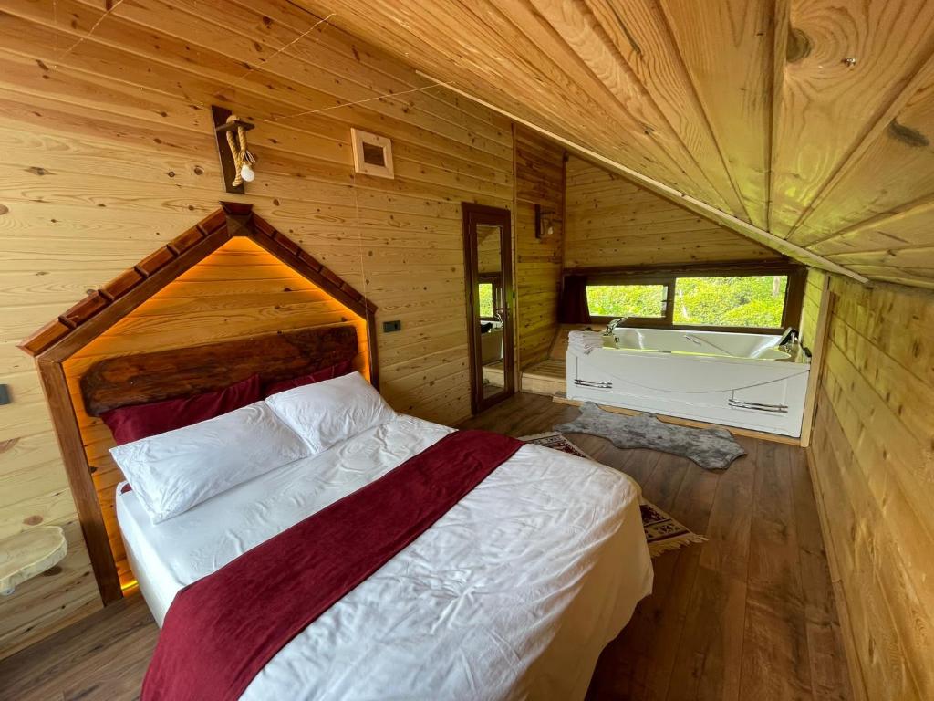 a bedroom with a bed in a wooden cabin at Vadi dağ evi bungalov in Çamlıhemşin