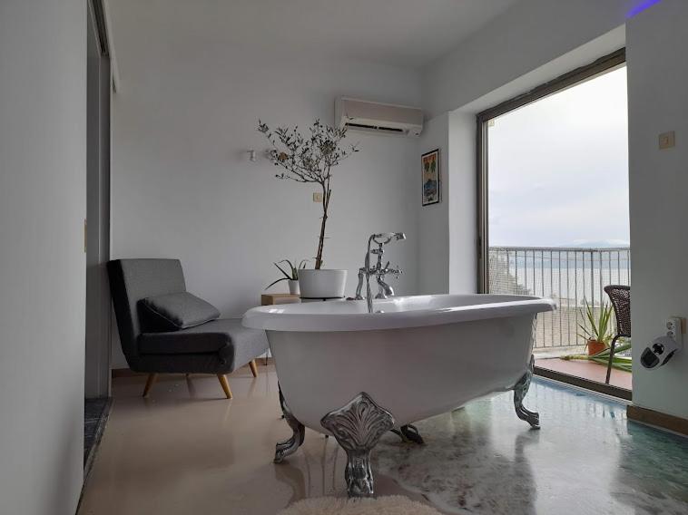 a white bath tub in a room with a window at Artemida in Loutra Edipsou