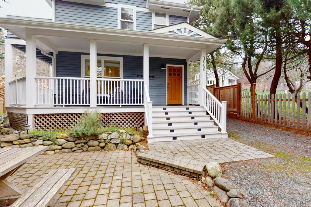 una pequeña casa azul con porche blanco y escaleras en Bay View Retreat en Eastsound