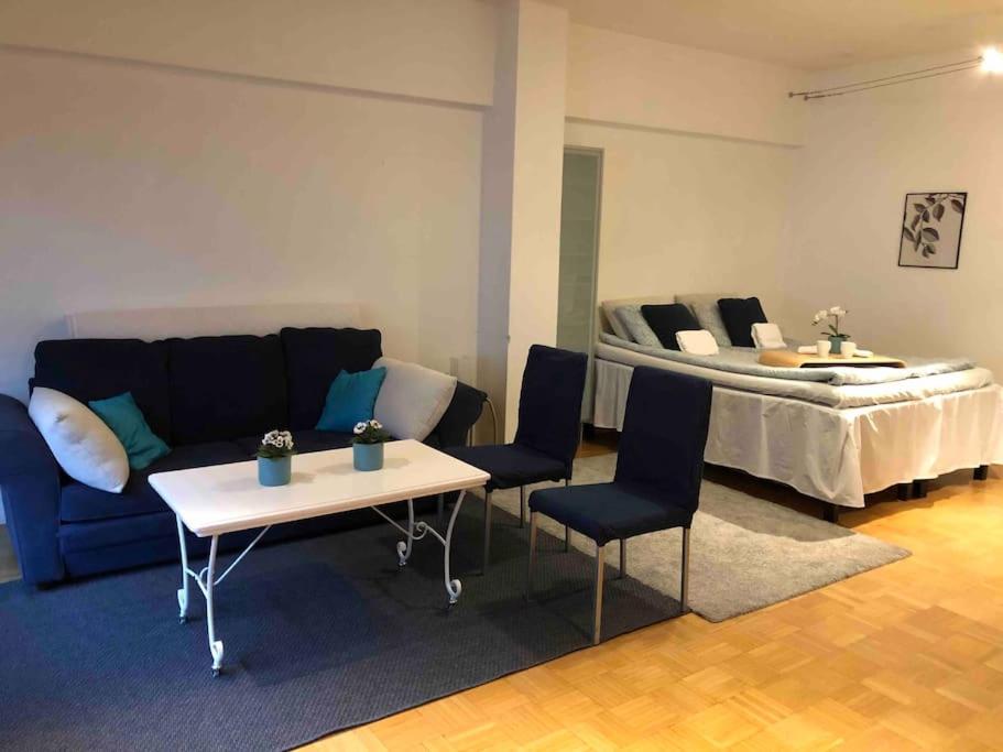 sala de estar con sofá, mesa y cama en Stylish spacious studio near centre by the sea, en Helsinki