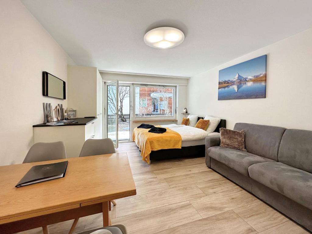 ein Wohnzimmer mit einem Bett und einem Sofa in der Unterkunft Phoenix Studio - Haus Astral - Zermatt in Zermatt