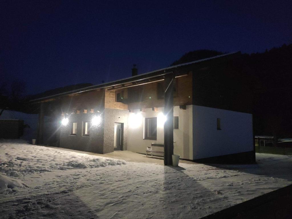 ein Haus, das nachts im Schnee leuchtete in der Unterkunft Apartmány pri Jaskyni - Bystrá in Bystrá