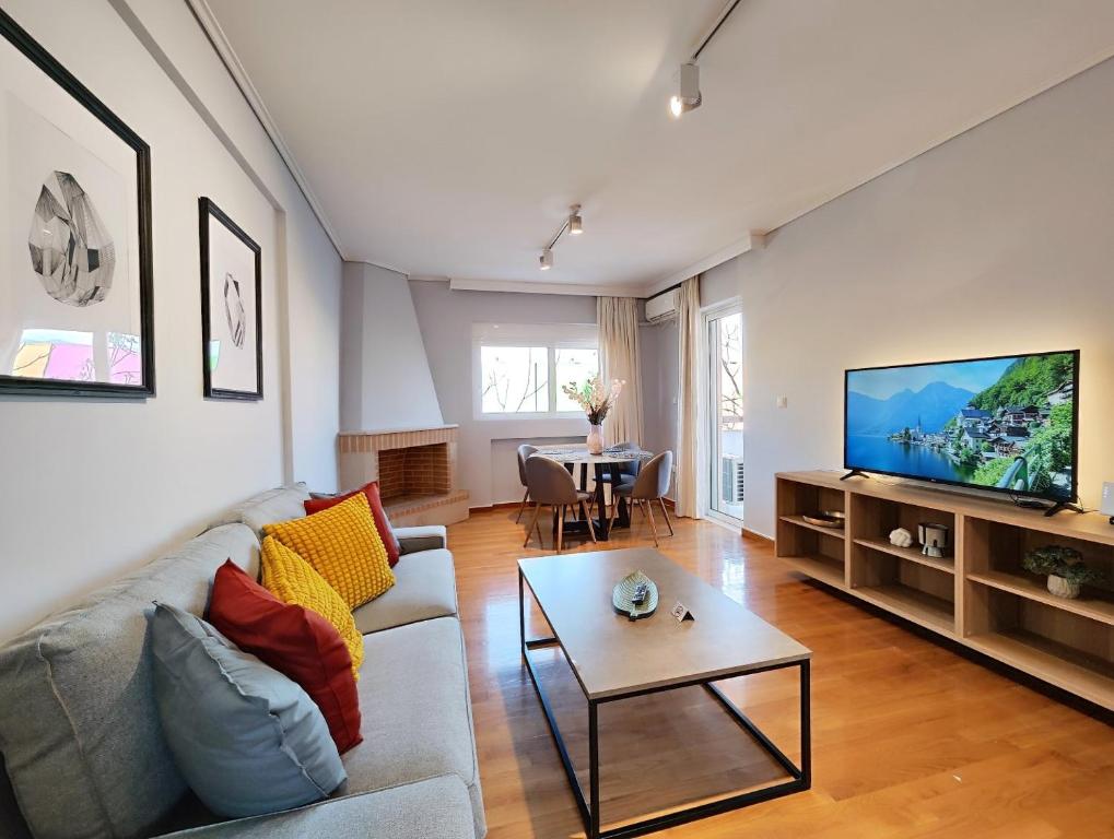 a living room with a couch and a flat screen tv at Menelaou by Verde Apartments in Athens