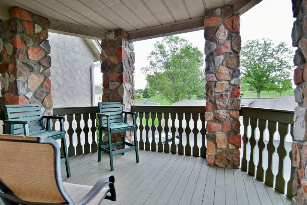 un porche con sillas azules y una pared de piedra en Unit 207 2 BDRM 2 BA condo, en Birchwood