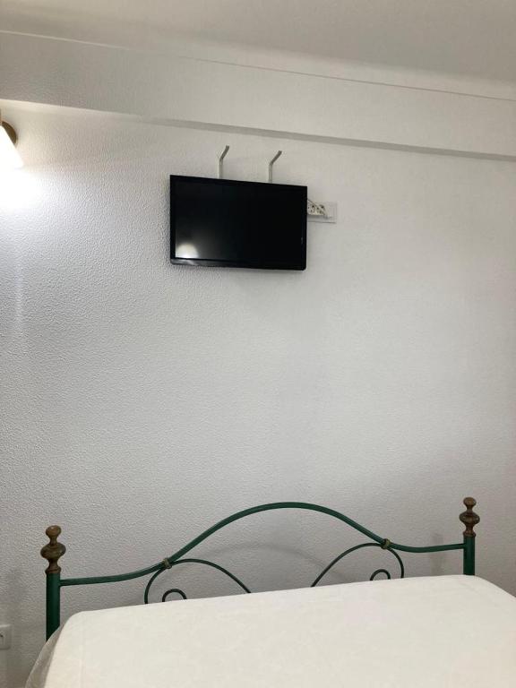 a bedroom with a bed with a television on the wall at Casa da Nazaré in Portinho da Arrábida