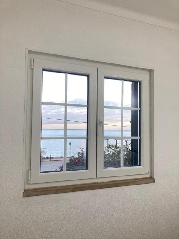 a window in a room with a view of the ocean at Casa da Nazaré in Portinho da Arrábida