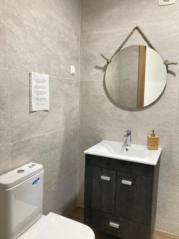 a bathroom with a toilet and a sink and a mirror at Casa da Nazaré in Portinho da Arrábida