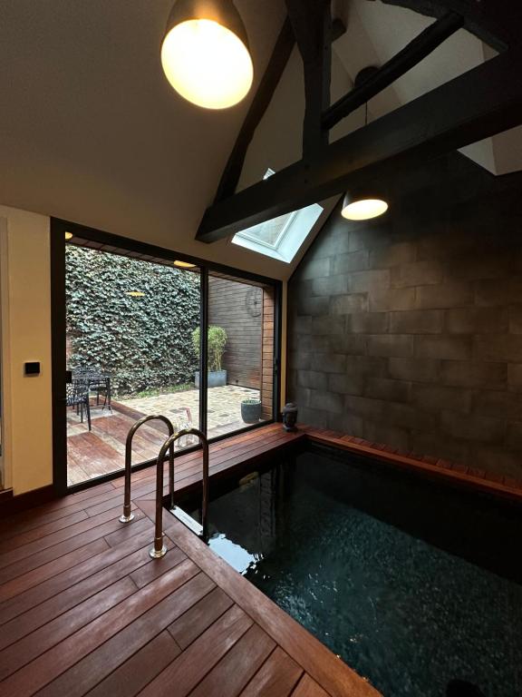 a swimming pool in a house with a window at À contre courant in Forges-les-Eaux
