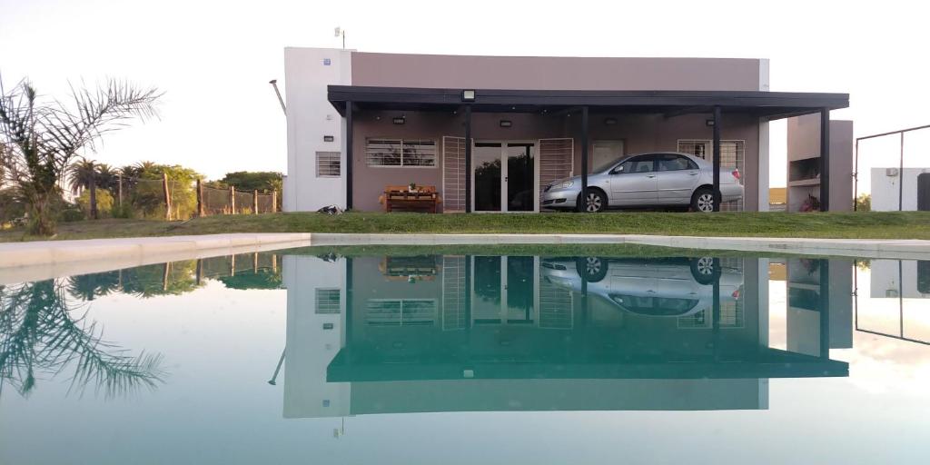 una casa con un reflejo en una piscina de agua en Quinta al sur - Quinta con pileta en Paraná en Paraná
