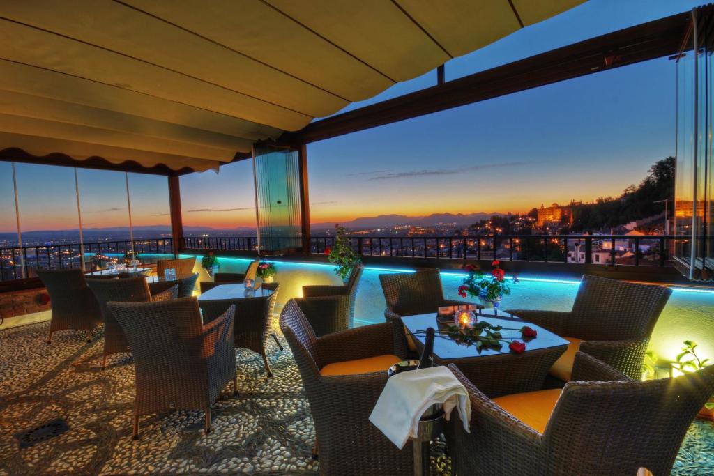a restaurant with a view at night at Hotel Mirador Arabeluj in Granada