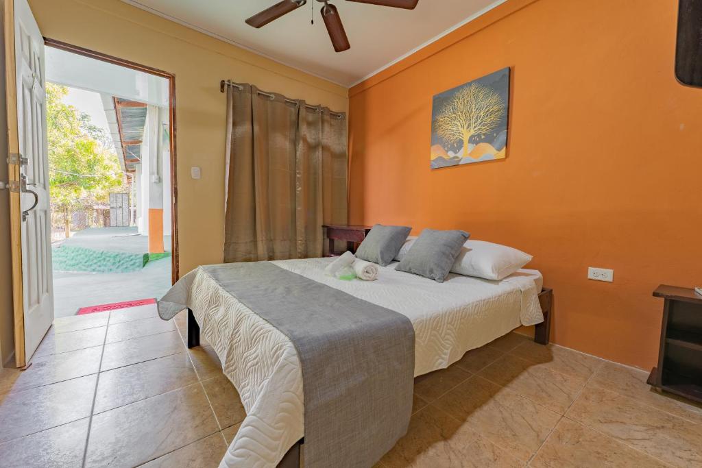 ein Schlafzimmer mit einem Bett mit einer orangefarbenen Wand in der Unterkunft El Cocobolo Food&Rest Room 2 Bed and Breakfast WiFi AC Pkg gratis 