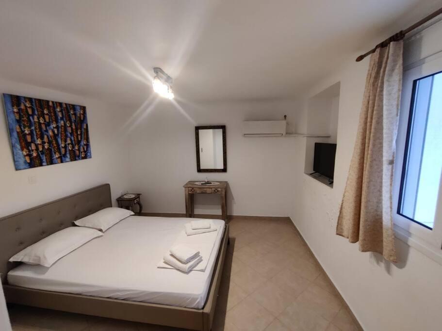 een kleine slaapkamer met een bed en een raam bij Kostas' House in Piraeus