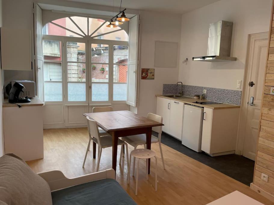 a kitchen and dining room with a table and chairs at Appartement 2 pièces Classé 2 * * in Janzé