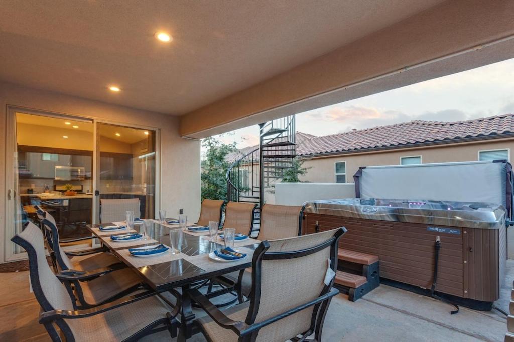 ein Esszimmer mit einem Tisch und Stühlen auf einer Terrasse in der Unterkunft Paradise Village 111 Private Hot Tub, Fire Pit, Nintendo Switch, Ping Pong, Pickle ball Equipment, Games, and More in Santa Clara