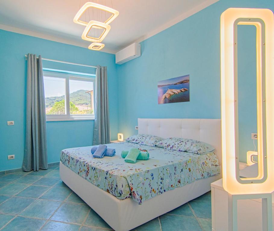 ein blaues Schlafzimmer mit einem Bett und einem Spiegel in der Unterkunft Appartamenti Mare Portoferraio in Portoferraio