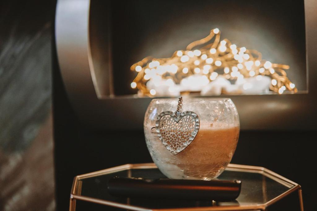 a glass vase with a heart on a glass table at Mamma Mia Hotel Boutique - Only Adults in Tossa de Mar