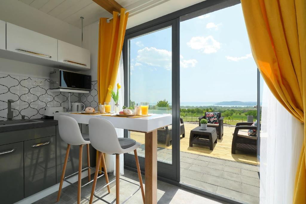 a kitchen with a table and chairs and a large window at Lotti Residence Harmony in Balatonfüred