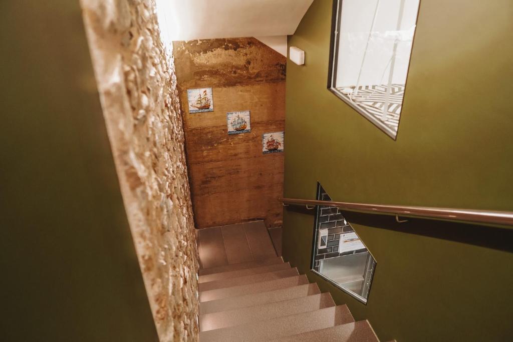 a staircase in a room with green walls and a window at Mamma Mia Hotel Boutique - Only Adults in Tossa de Mar