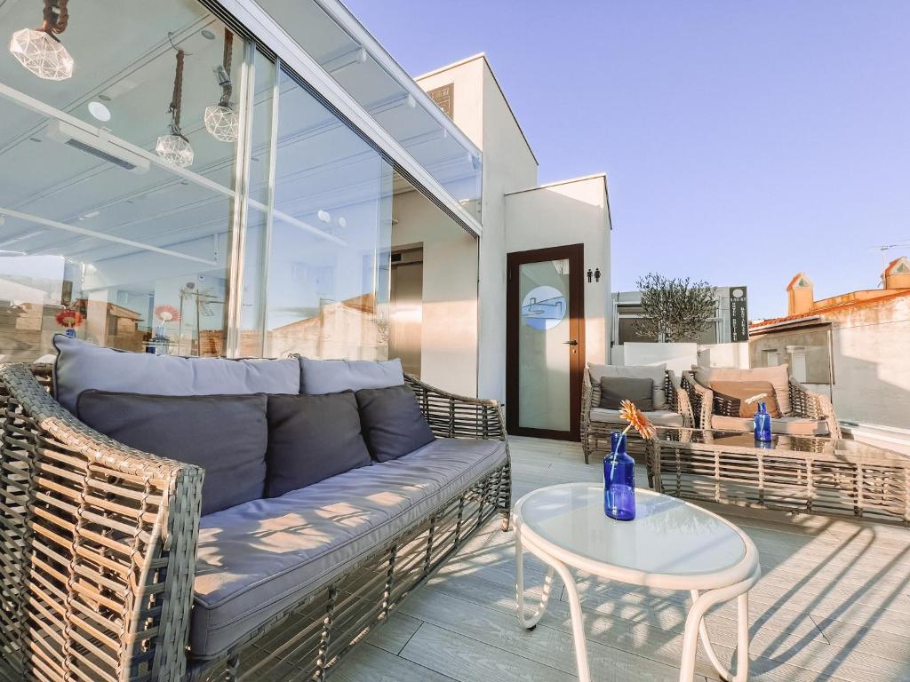 ein Sofa und einen Tisch auf einer Terrasse in der Unterkunft Mamma Mia Hotel Boutique - Only Adults in Tossa de Mar