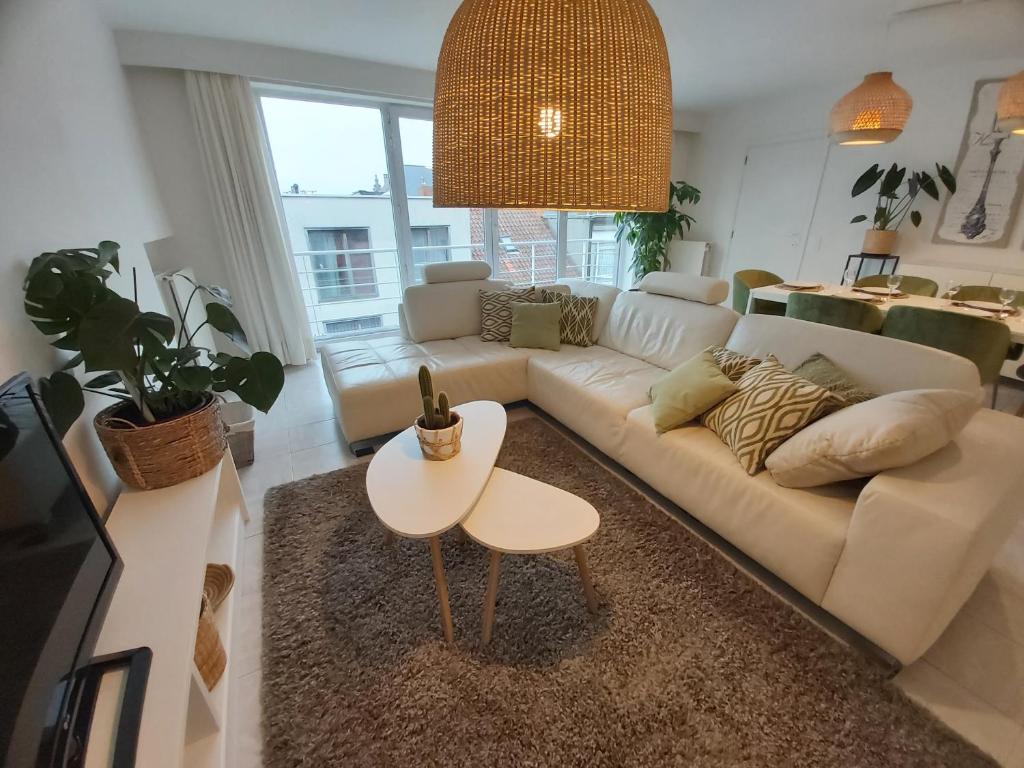 a living room with a white couch and a table at Sea & the City in Blankenberge