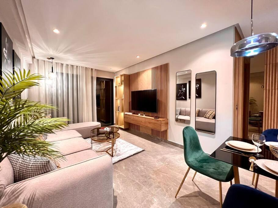 a living room with a couch and chairs and a television at Centro 2 Bedrooms- By AppartAli in Casablanca