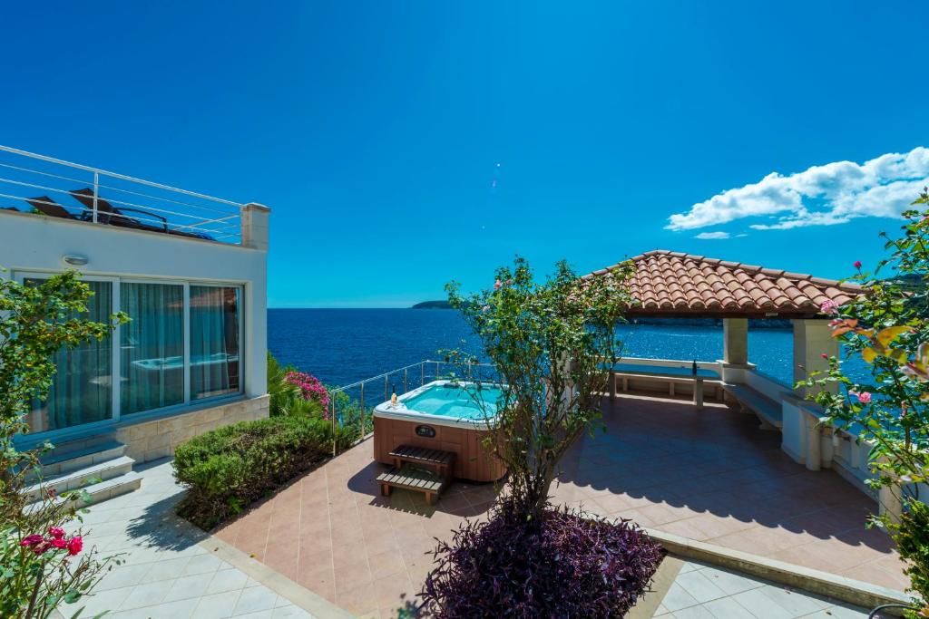 a house with a hot tub and the ocean at Villa Vacanza Dubrovnik - Five Bedroom Villa with Private Sea Access in Dubrovnik