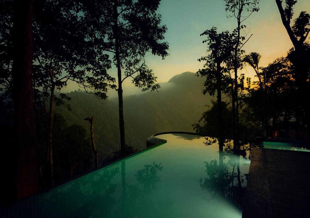 una piscina con vista sulle montagne di Chembarathi Wayanad Boutique Resort a Vaduvanchal