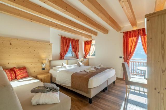 een grote slaapkamer met 2 bedden en een balkon bij Agritur Darial in Tesero