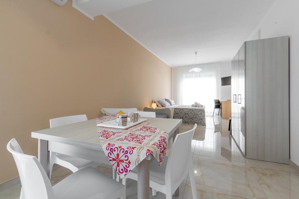 une salle à manger blanche avec une table et des chaises blanches dans l'établissement Mare Manu Appartamento, à Porto Cesareo