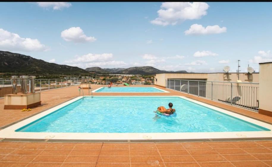 una persona en una piscina en la parte superior de un edificio en Apartamento Solêa, en Tarragona