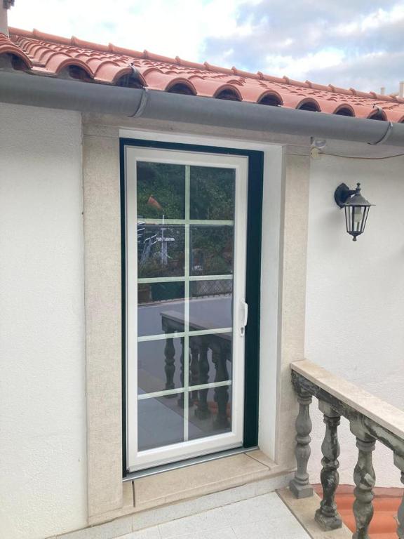 a door to a house with a window at Casa da Nazaré in Portinho da Arrábida