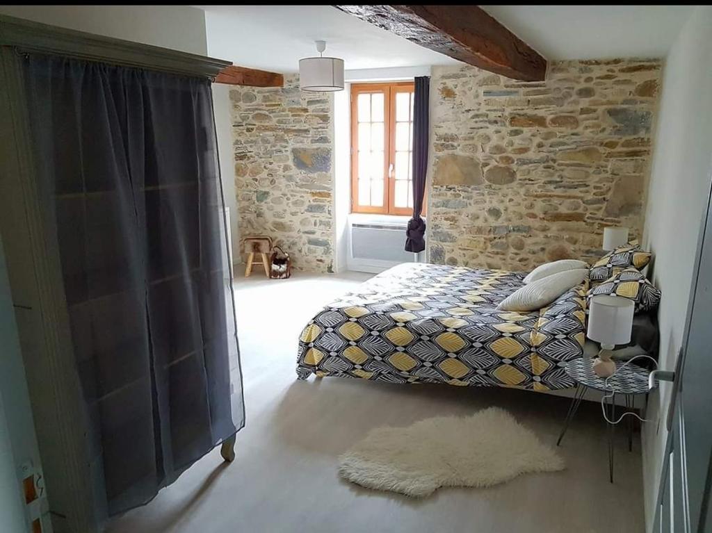 1 dormitorio con cama y pared de ladrillo en Peyo et Foodie en Escou