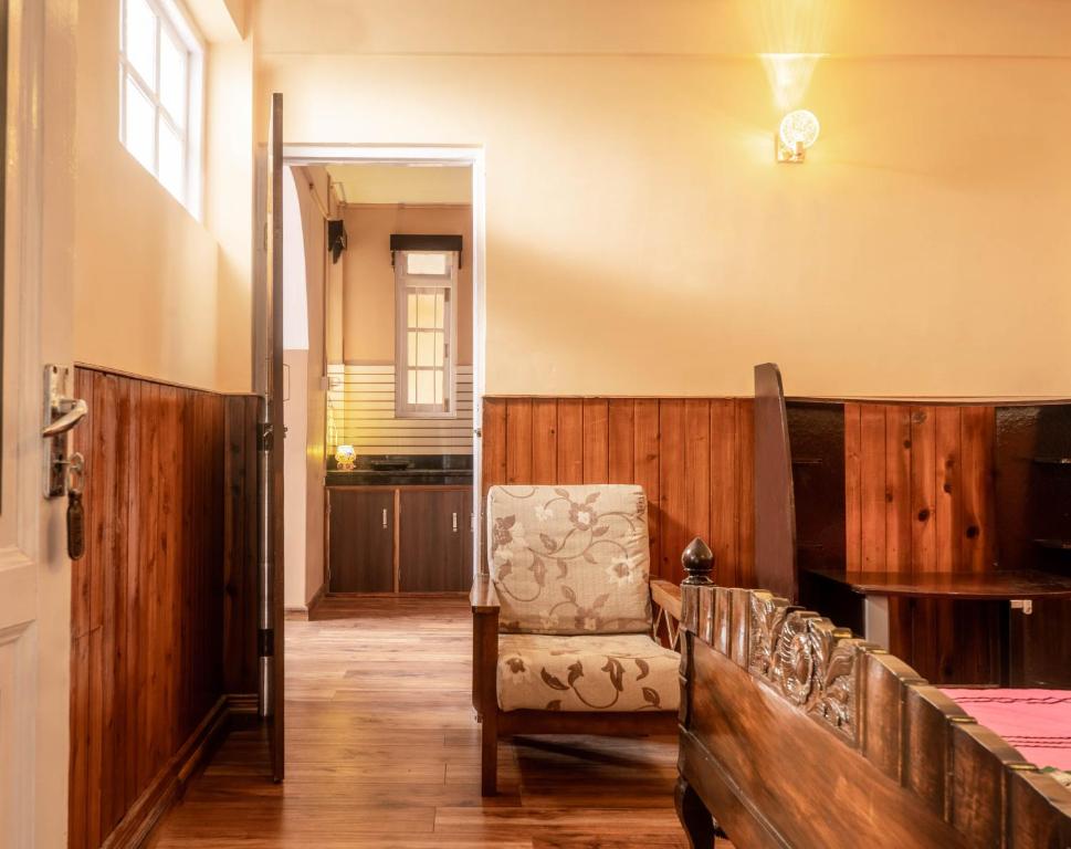 a living room with a chair and a table at Augusta Villa in Darjeeling