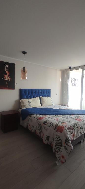 uma cama com uma cabeceira azul num quarto em Hermoso Departamento con vista al Mar em Viña del Mar