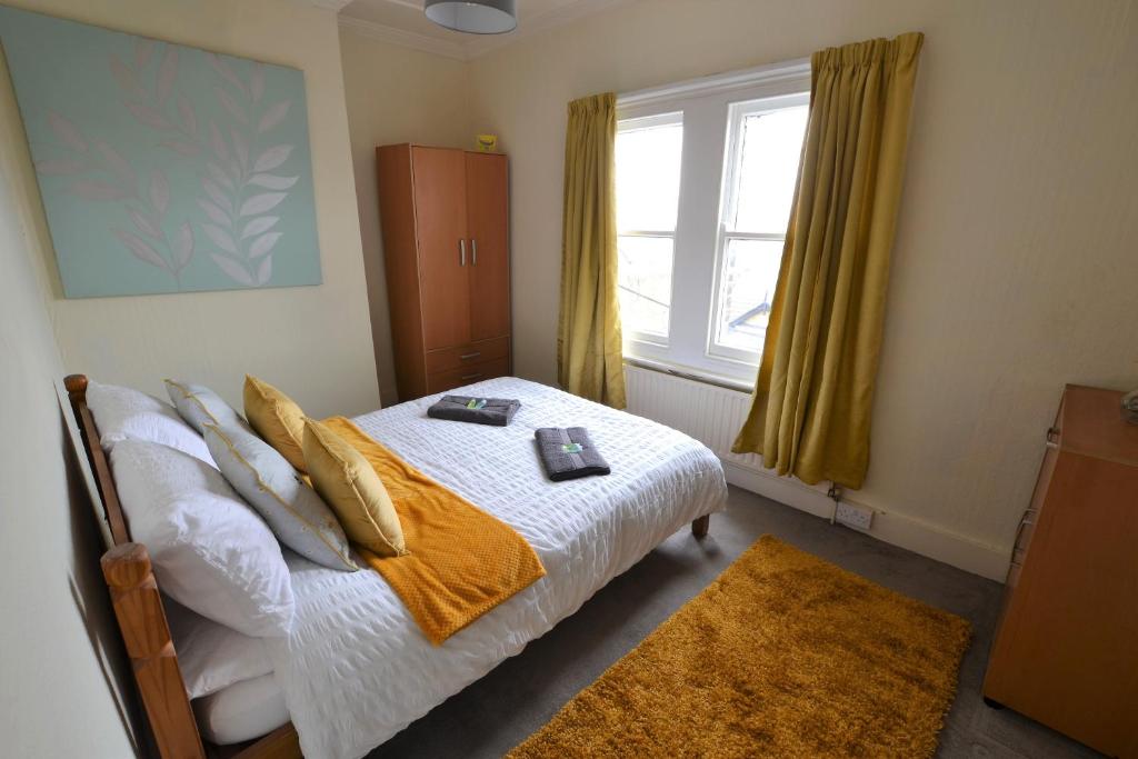 een slaapkamer met een bed en een raam bij Victoria Bay - Whole Apt - 2 Bed - WiFi - Beach - Harbour - Herne Bay in Herne Bay