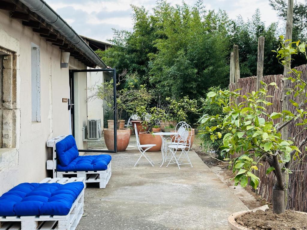 eine Terrasse mit zwei blauen Stühlen und einem Tisch in der Unterkunft CASA AZUL - jardin, calme, tennis in Nîmes