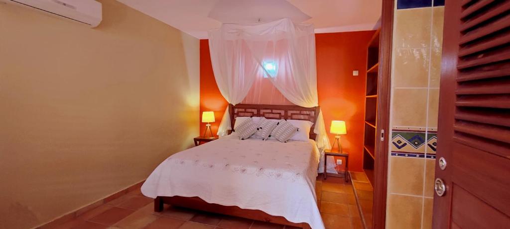 1 dormitorio con 1 cama con colcha blanca en T2 D'ALICE SAINTE ANNE CENTRE, en Sainte-Anne
