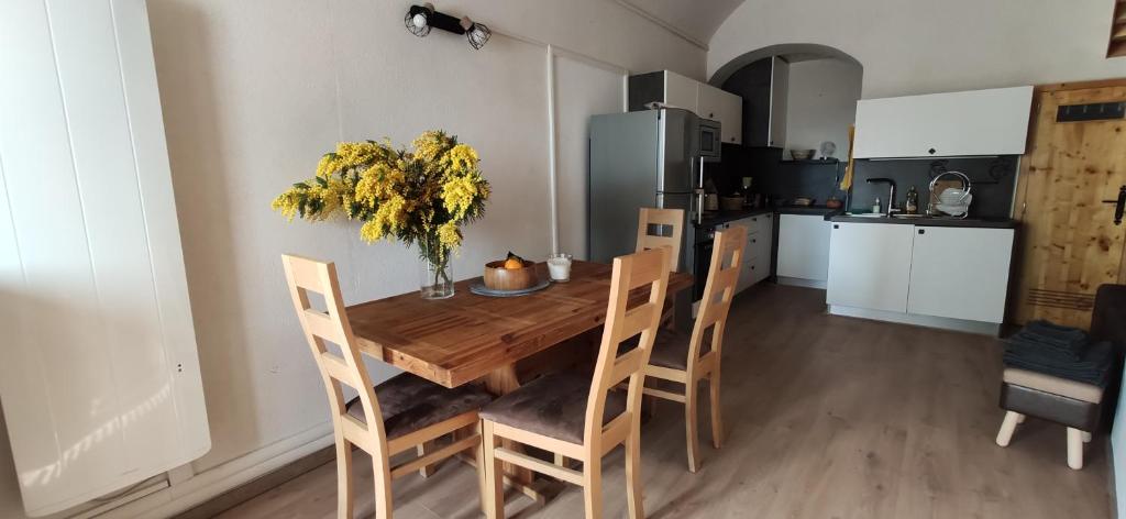 - une cuisine avec une table à manger en bois et des chaises dans l'établissement Logette à Ezio, zone piétonne, à Menton