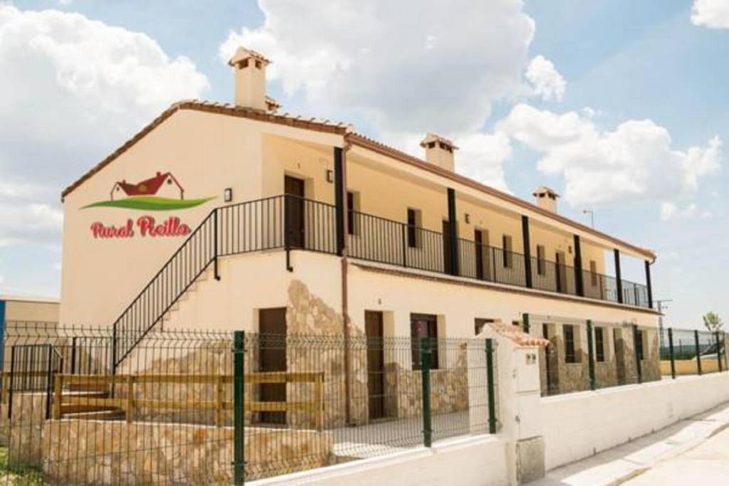 a building with a sign on the side of it at Rural Reillo Alojamientos Rurales in Reíllo