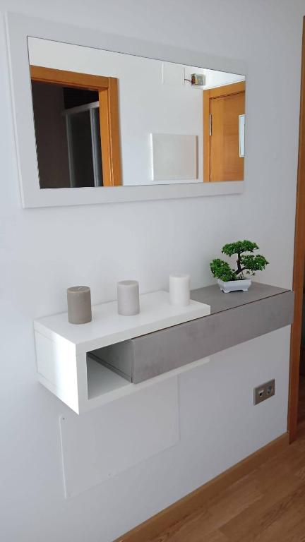 a bathroom with a white shelf and a mirror at Apartamento Area Maior in Malpica