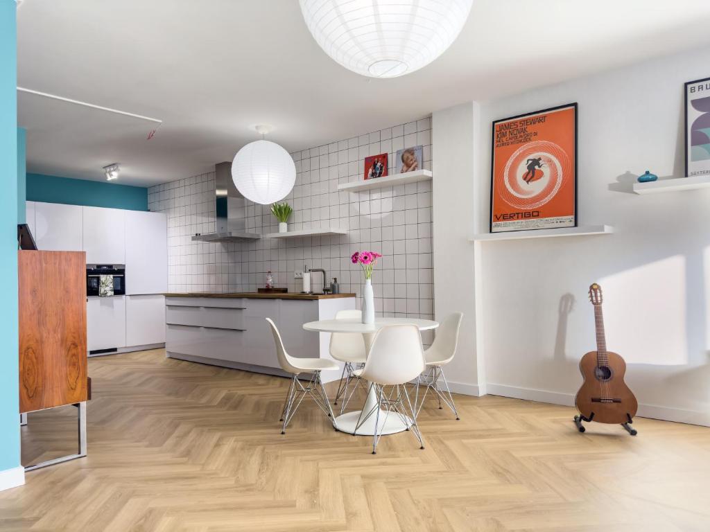 a kitchen and dining room with a table and a guitar at Rotterdam's coolest apartment in Rotterdam