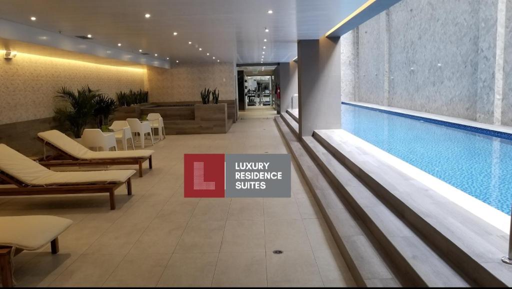 a swimming pool in a lobby with a pool table at Luxury Residence Suites in Quito