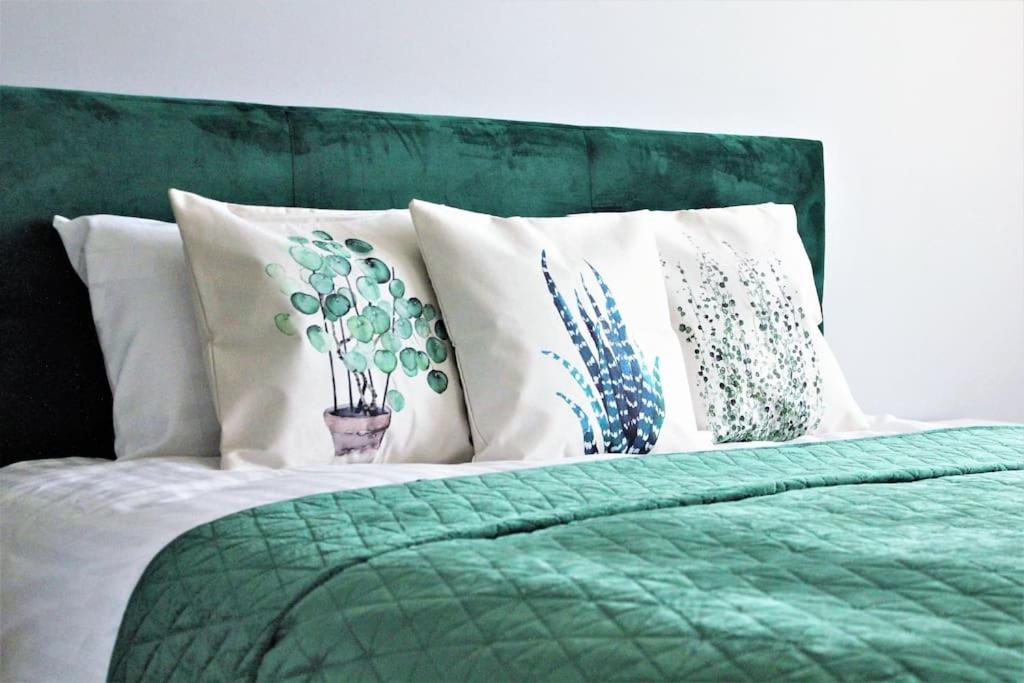 - un lit vert avec des oreillers blancs et une couette verte dans l'établissement Green bed by the pine forest, à Anykščiai