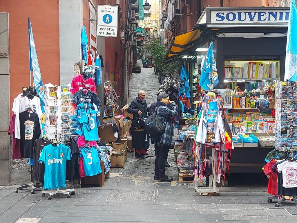een man die voor een winkel in een straat staat bij A Due Passi Da Toledo in Napels