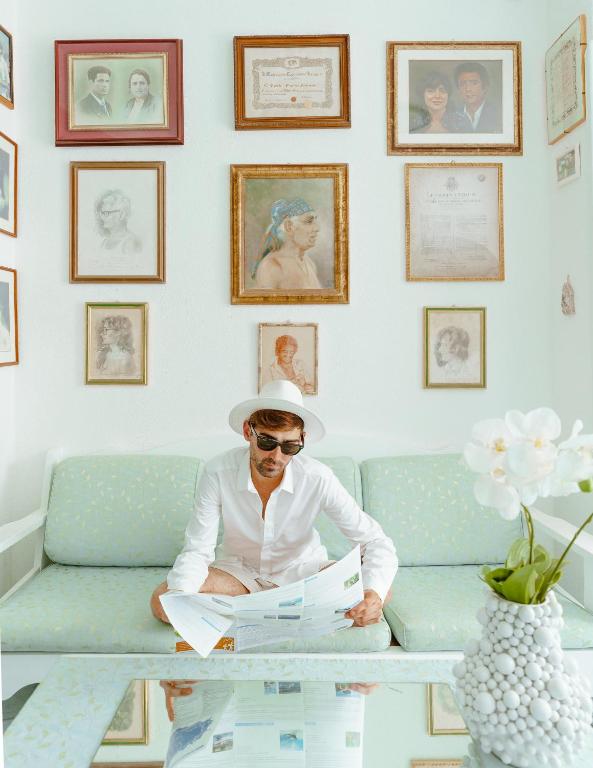 a man sitting on a couch reading a newspaper at Hotel Ferdinando Beach & Thermal Spa in Ischia